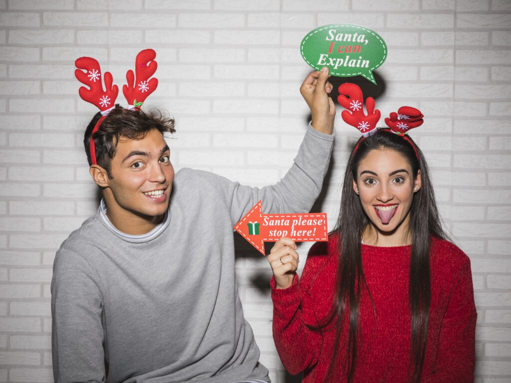 Celebrate the Season with a Holiday Photo Booth in Massachusetts Guests posing with holiday props in a festive photo booth in Massachusetts